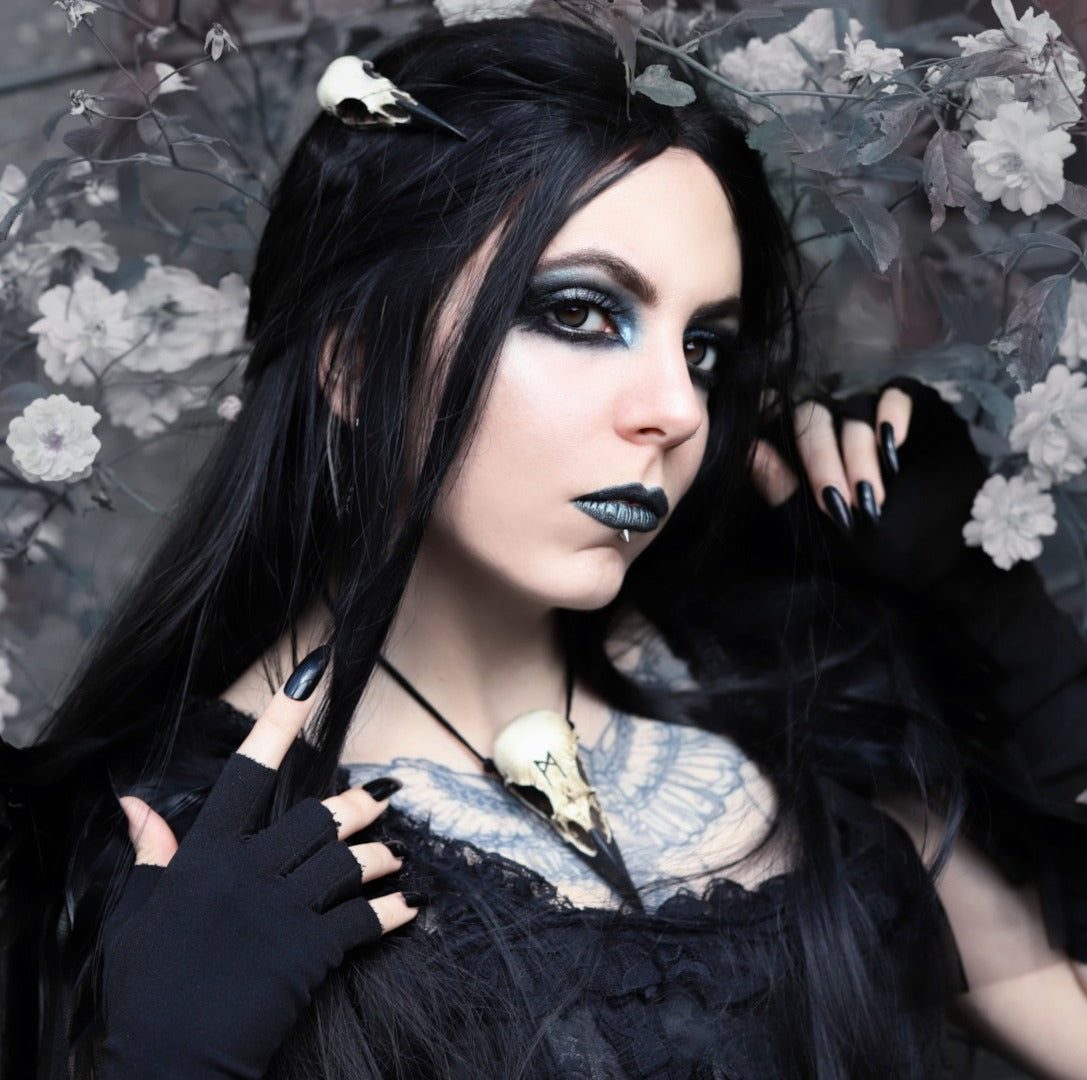raven skull necklace and raven skull hair clip worn by gothic model with tattoos