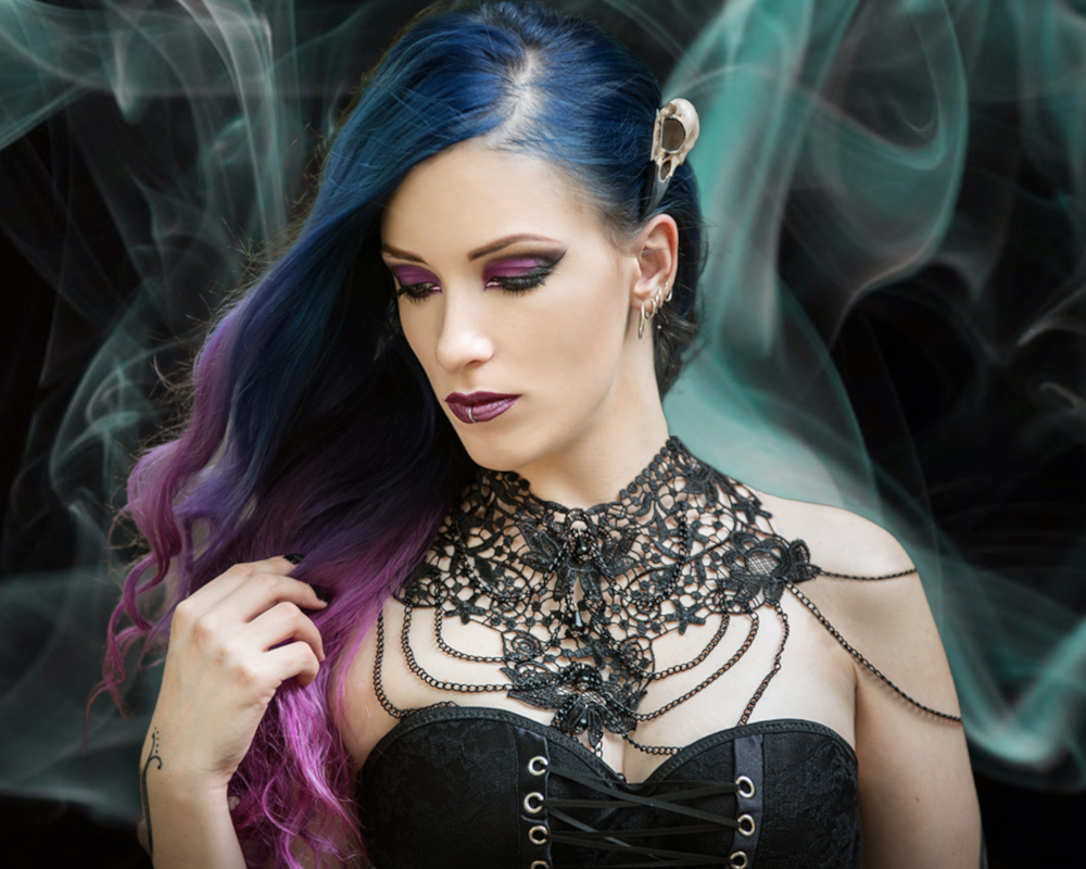 Raven skull hair clip bird skull hair accessory made by Raven Ranch Studio, worn by gothic model with purple blue hair.