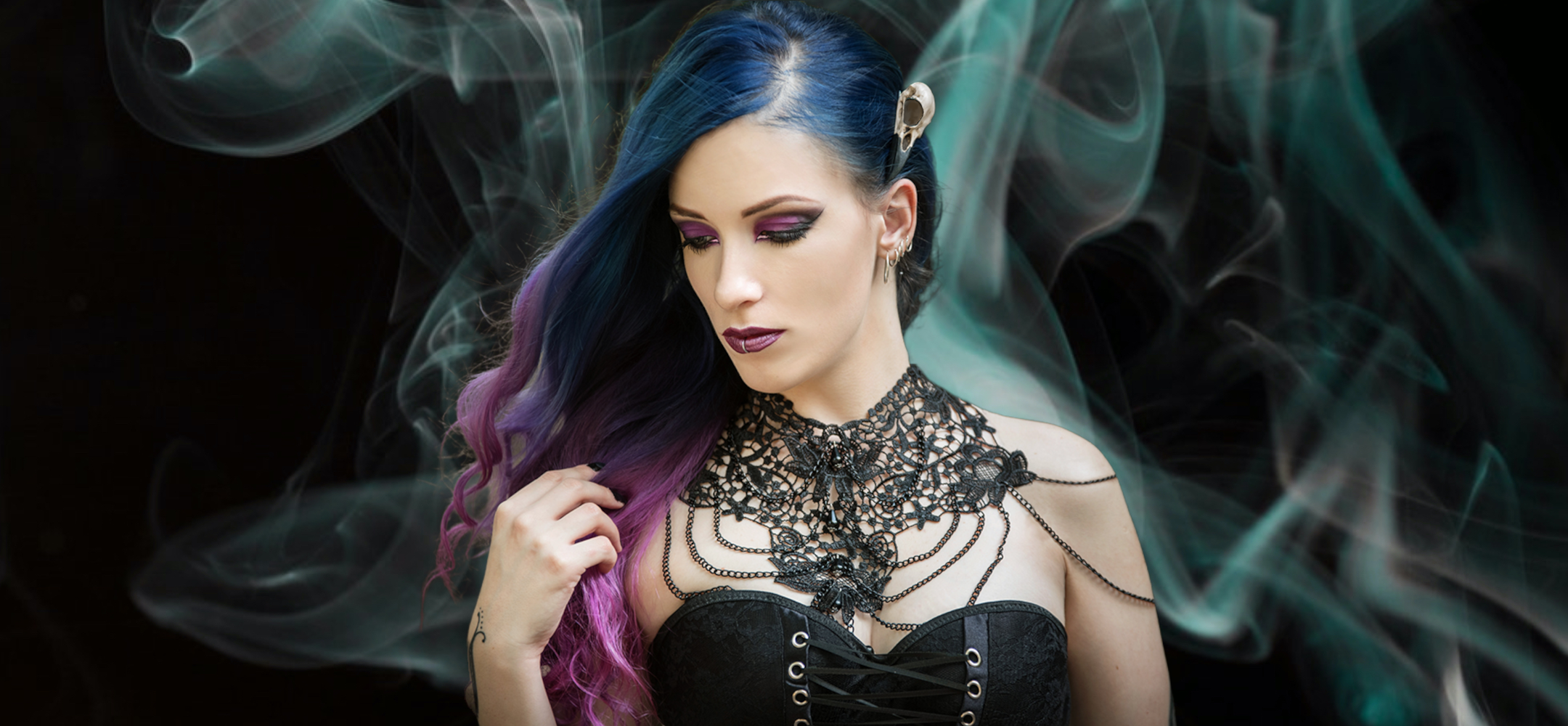 Raven skull hair clip bird skull hair accessory made by Raven Ranch Studio, worn by gothic model with purple blue hair.