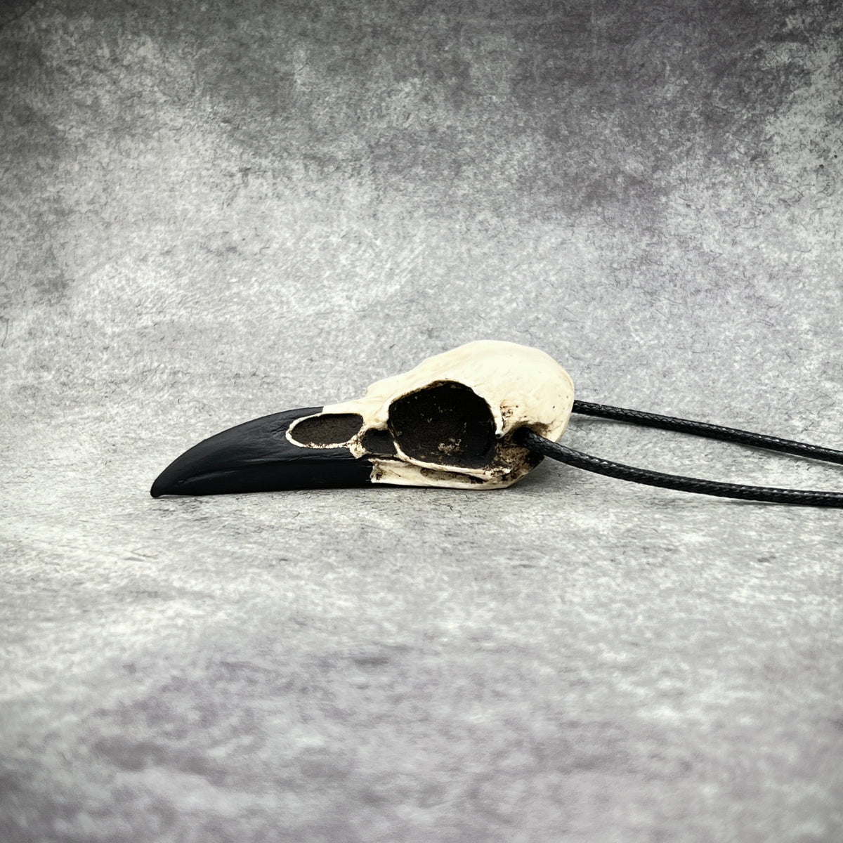 Animal skull jewelry bone clone cast resin replica of a real raven. Bird skull necklaces and raven skull pendants for goth and witchy women
