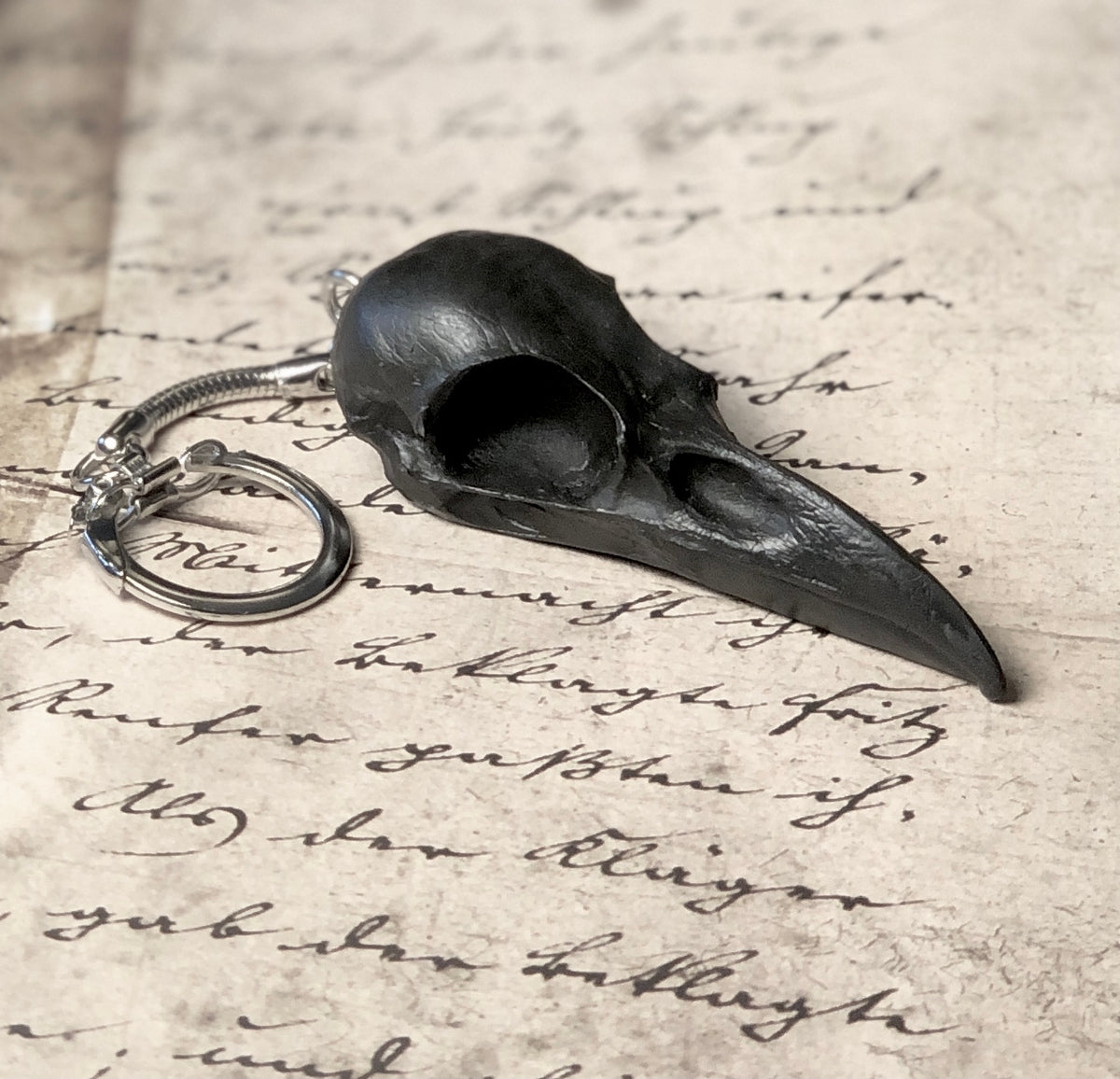 2.75 inch raven skull biker style keychain made of spooky black resin to look like a real bird skull key chain.