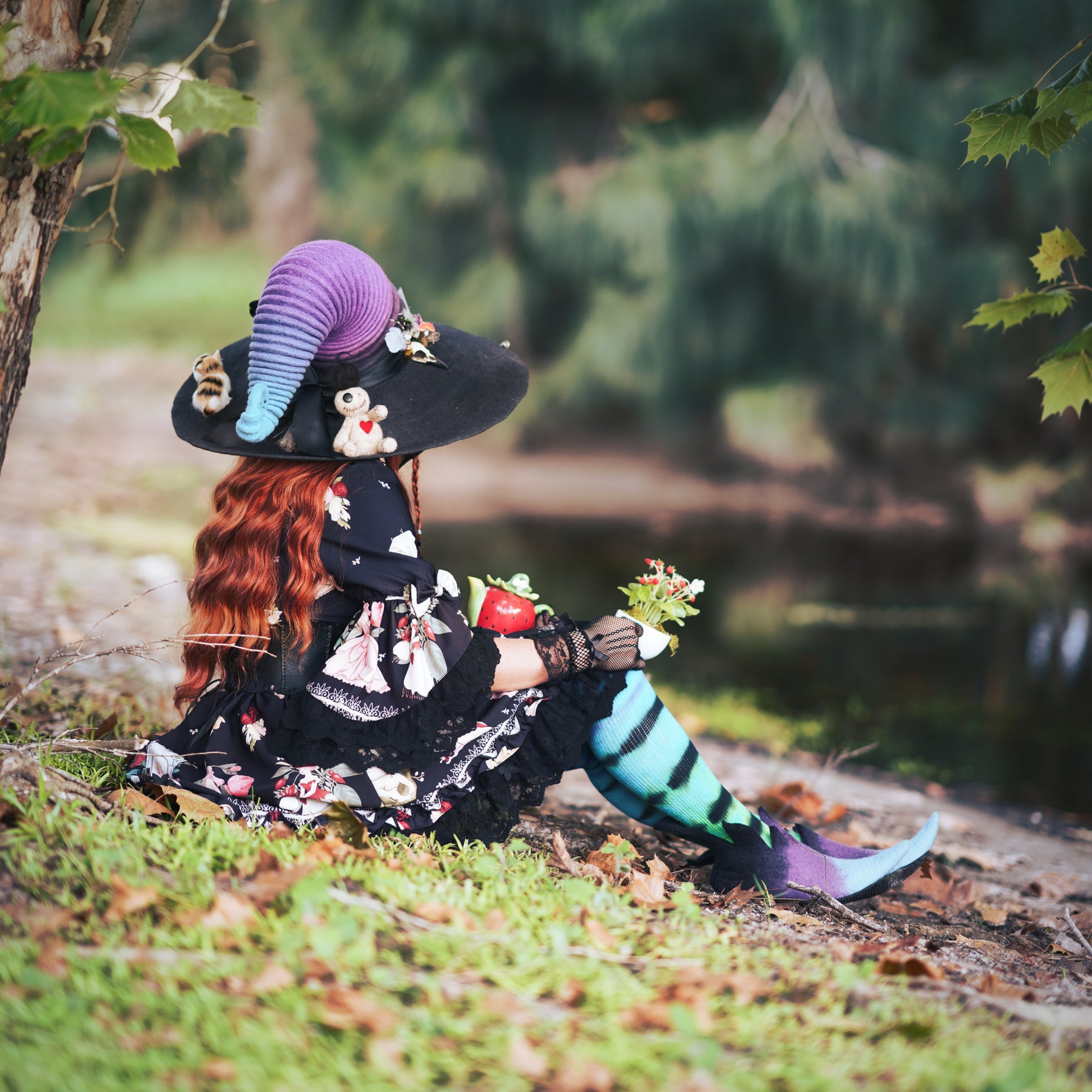 rainbow witch wearing handmade cosplay ren faire hat with a creepy unique bird skull raven hat pin brooch.