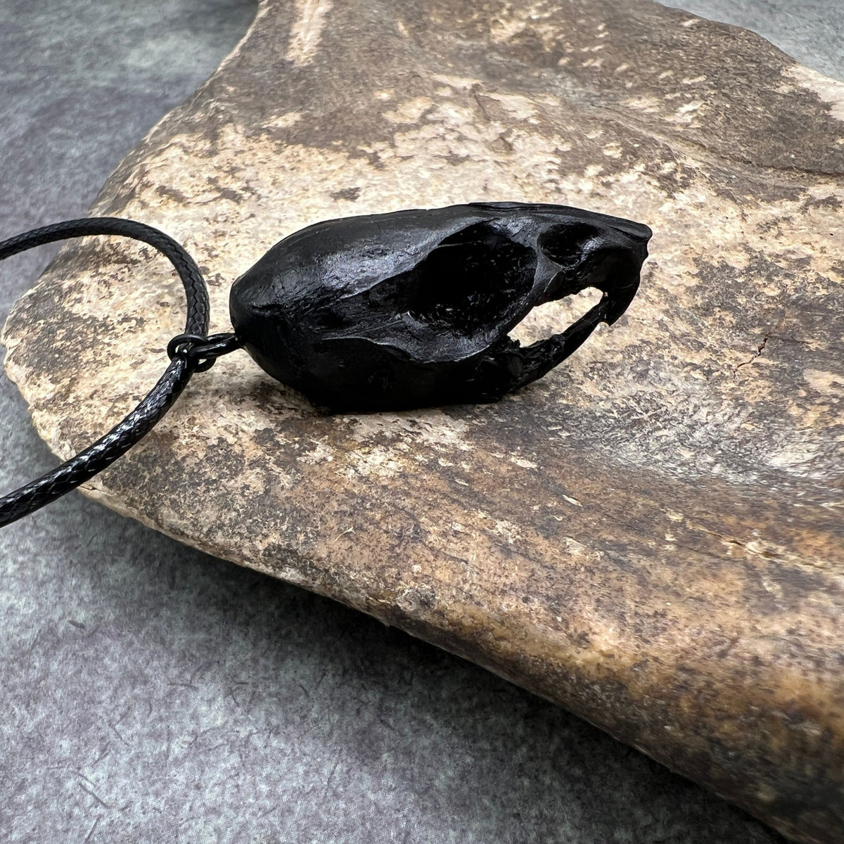 Right side view of a bone jewelry black resin rat skull necklace pendant for goths that love Halloween and taxidermy accessories.