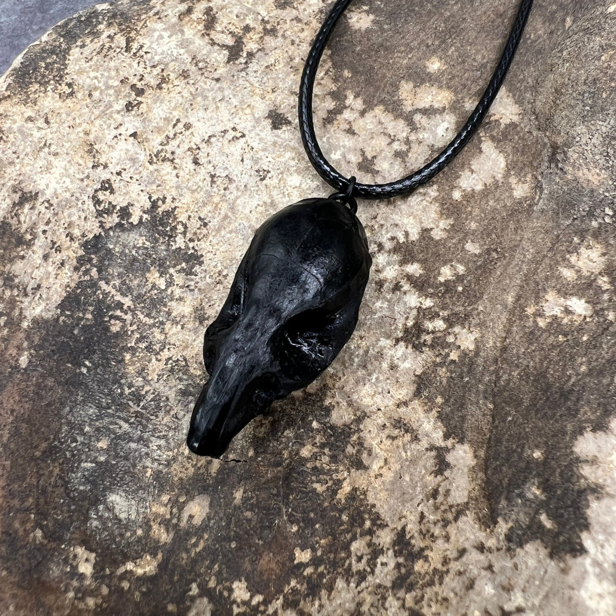 Top view of a bone jewelry black resin rat skull necklace pendant for goths that love Halloween and taxidermy accessories.