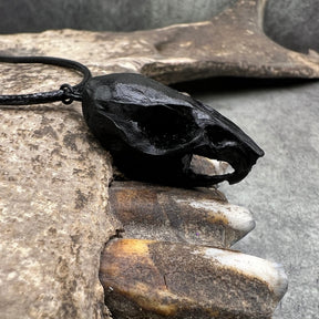 Close up side view of a bone jewelry black resin rat skull necklace pendant for goths that love Halloween and taxidermy accessories.