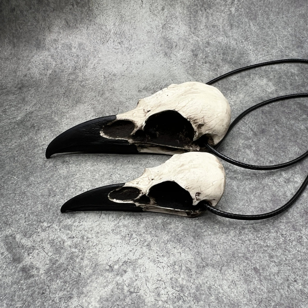 Large life size resin raven skull necklace pendant bone jewelry and a mini raven animal skull that are sold as a witchy gift set.