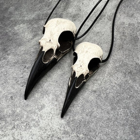 Large life size resin raven skull necklace pendant bone jewelry and a mini raven animal skull that are sold as a goth gift set for ren faire or festival outfits.