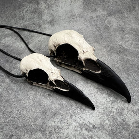 Large life size resin raven skull necklace pendant bone jewelry and a mini raven animal skull that are sold as a goth gift set for Halloween costume jewelry.