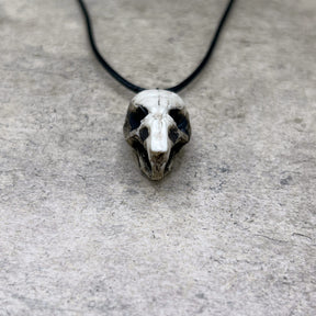 Close up view of a bone jewelry aged patina resin rat skull necklace pendant for goths that love Halloween and taxidermy accessories.