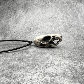 Right side view of a bone jewelry aged patina resin rat skull necklace pendant for goths that love Halloween and taxidermy accessories.