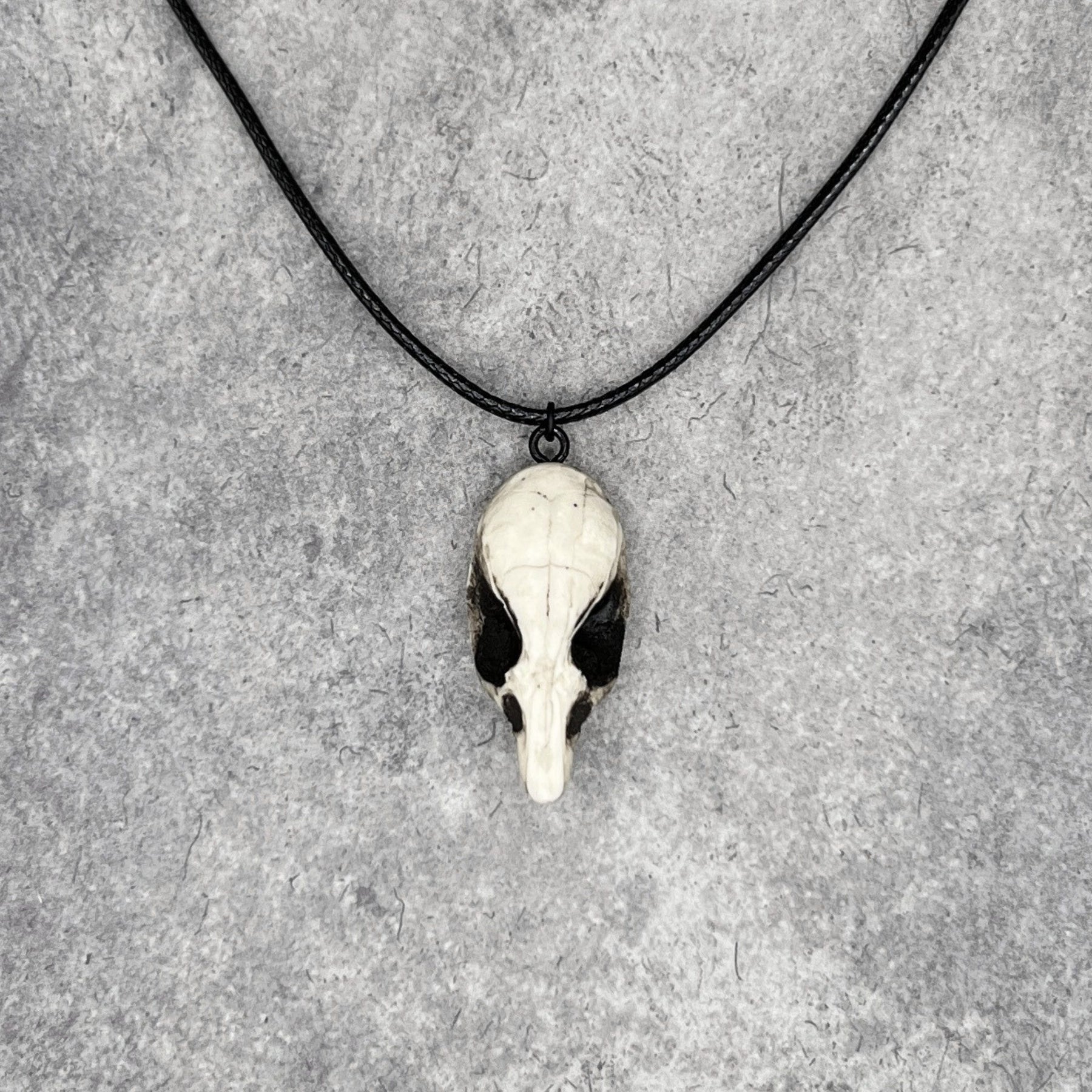 Front view of a bone jewelry aged patina resin rat skull necklace pendant for goths that love Halloween and taxidermy accessories.