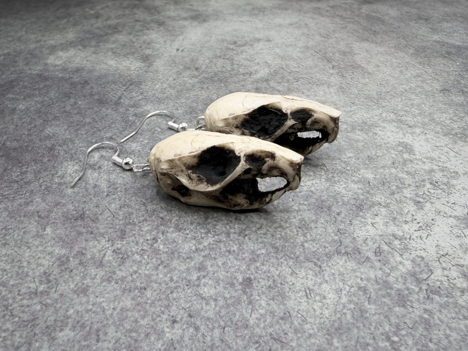 resin rat skull dangle earrings for goths that love bone jewelry, creepy accessories, witchy style and Halloween jewelry.
