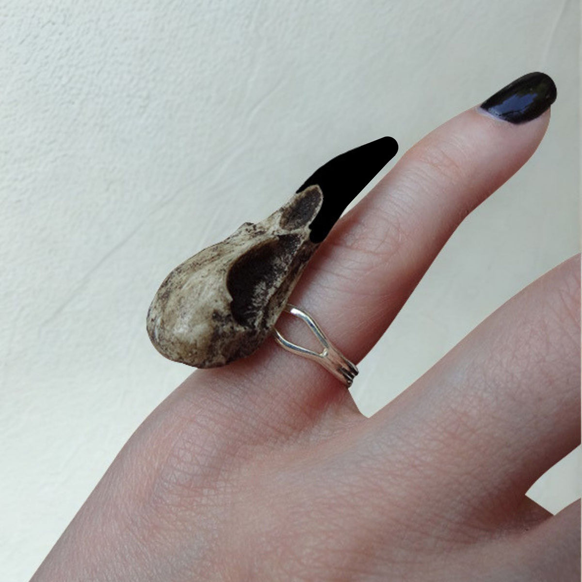Gothic bird skull witchy style resin raven skull ring. A miniature raven skull ring that is a bird skull jewelry accessory for goths, ren faire, festivals and halloween costumes. The skull has a patina aged finish with black beak.