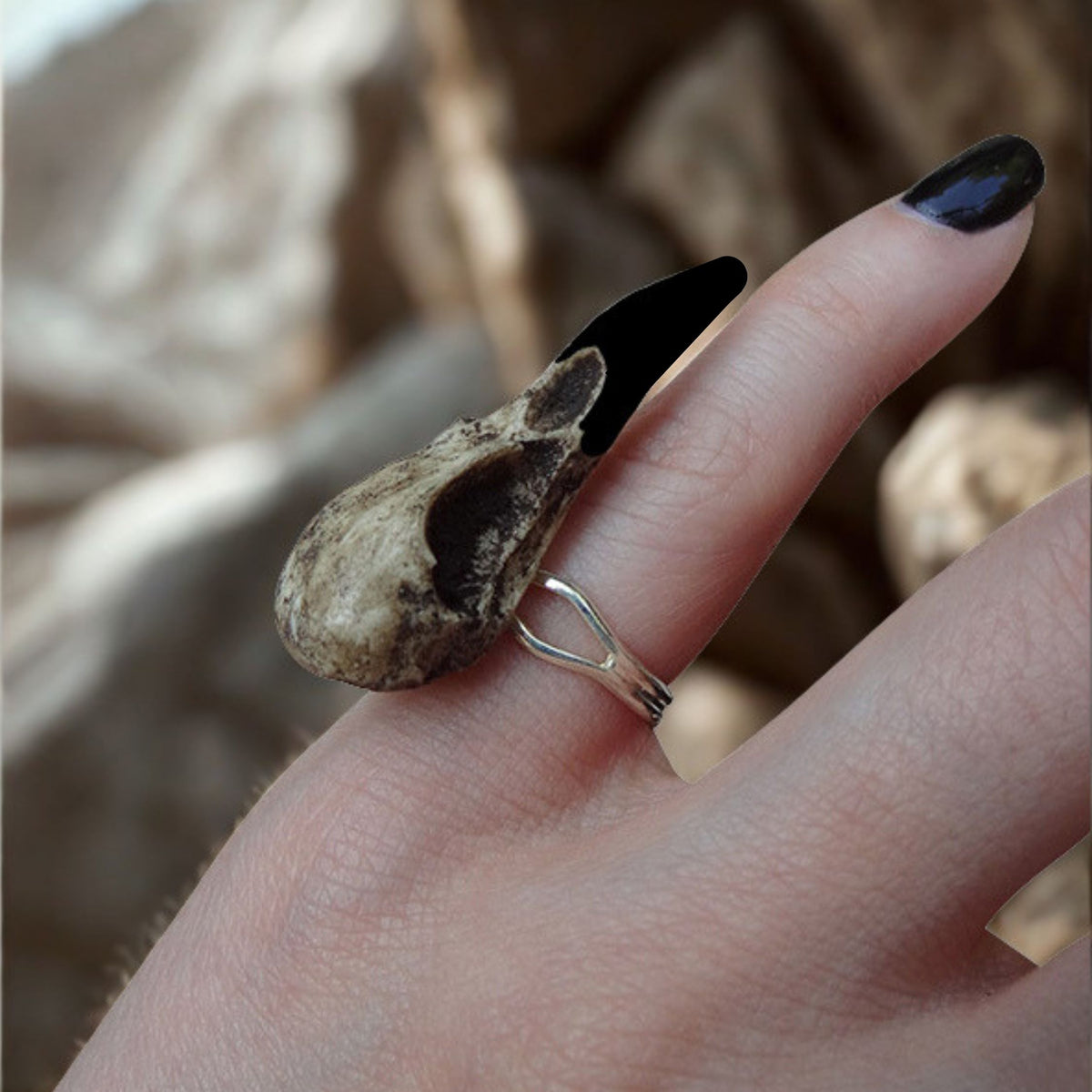 Gothic bird skull witchy style resin raven skull ring. A miniature raven skull ring that is a bird skull jewelry accessory for goths, ren faire, festivals and halloween costumes. The skull has a patina aged finish with black beak.