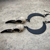 Dangle earlobe raven goth skull charm lunar celestial earrings with crescent moons and resin bird skulls.
