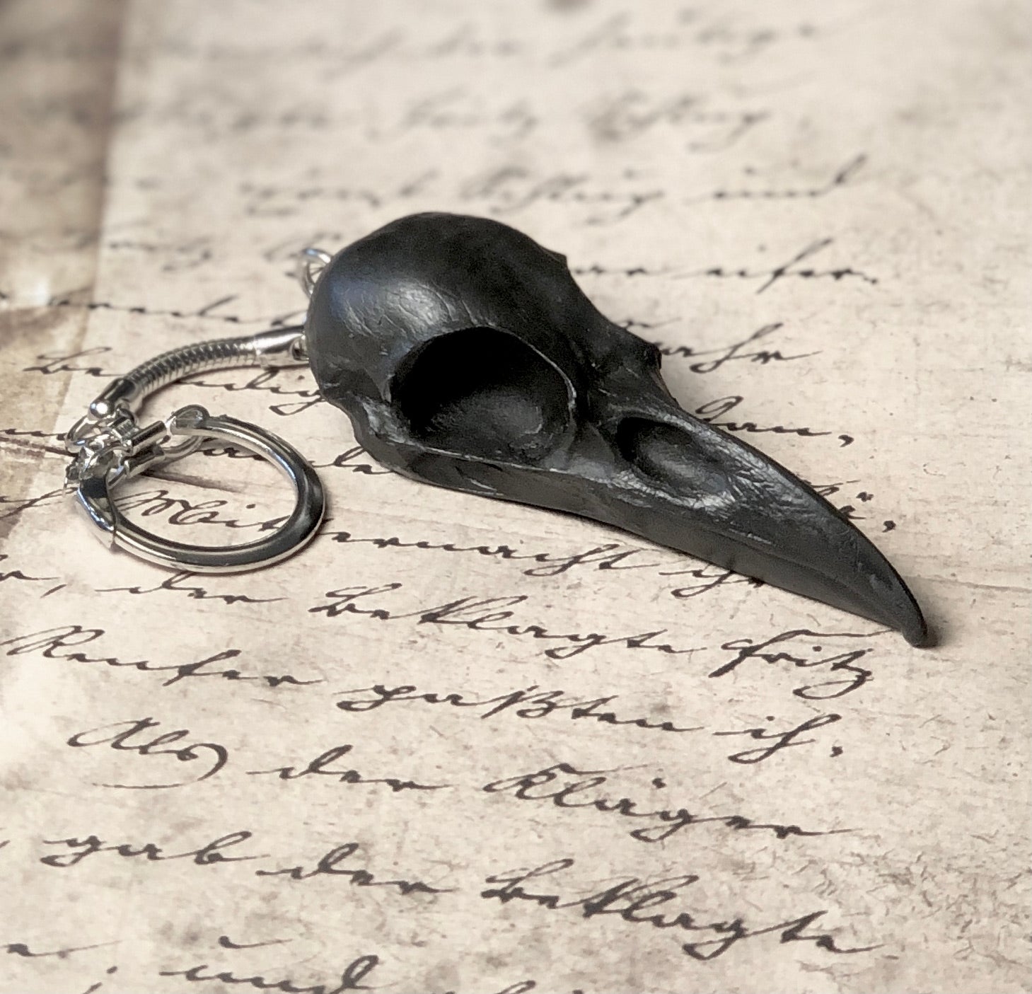 2.75 inch raven skull biker style keychain made of spooky black resin to look like a real bird skull key chain. 