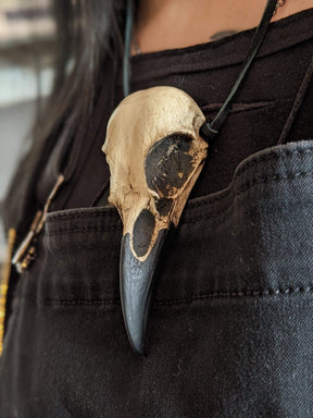Dirty creepy raven bone jewelry pendant bird skull necklace close up view.