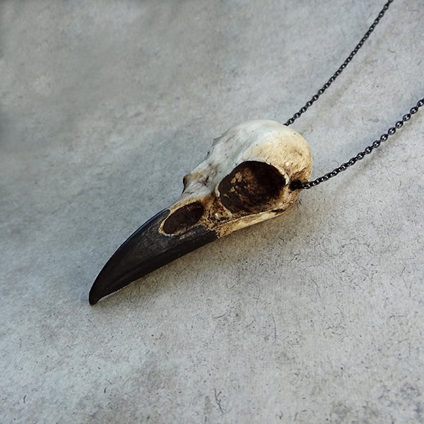mini size resin raven skull necklace pendant bone jewelry animal skull that is sold as part of a three piece set.