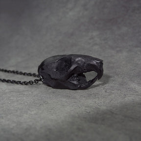 Side view of a bone jewelry black resin rat skull necklace pendant for goths that love Halloween and taxidermy accessories.