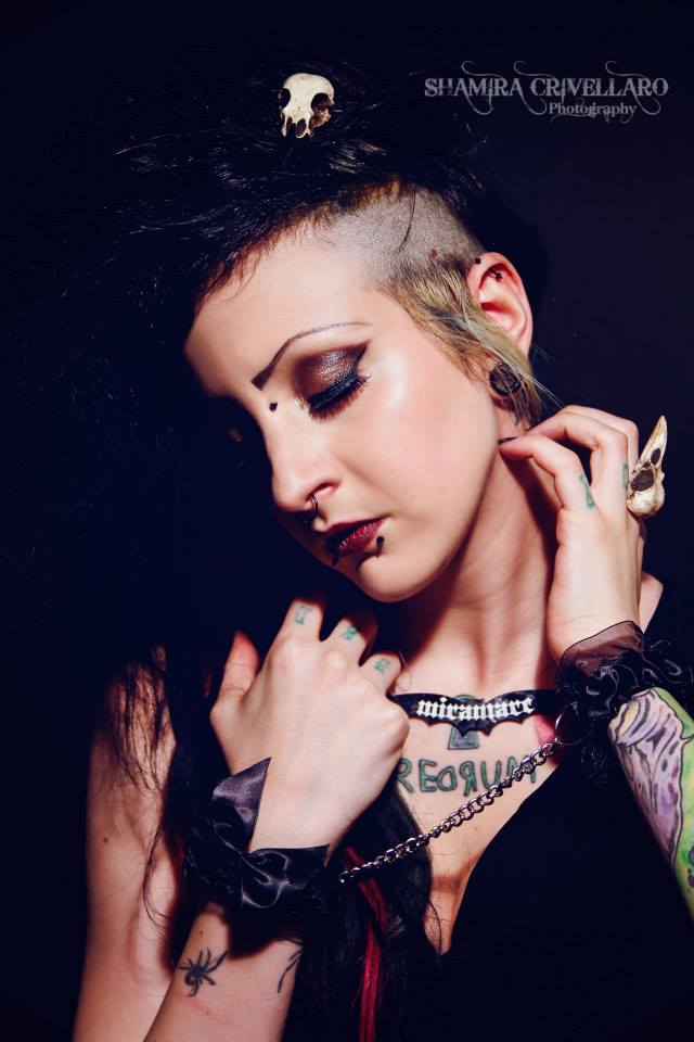punk rock girl with bone jewelry raven skull ring on her hand and a bird skull hair clip in her hair.