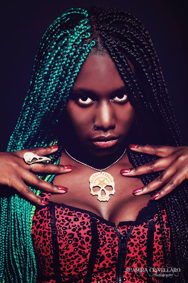 alternative girl with bone jewelry raven skull ring on her hand.