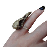 Gothic style resin raven skull ring with aged patina finish on hand with witchy black nails.