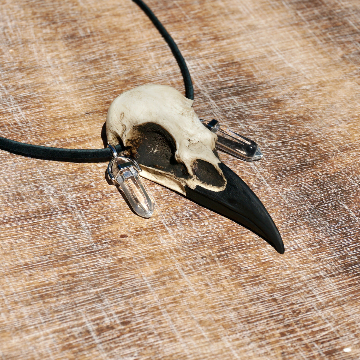 Healing quartz crystal bird skull necklace raven pendant on suede leather cord and two crystal points on each side of the skull.